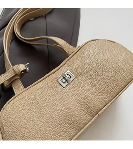 Detail der beigen Handtasche aus Narbenleder mit silbernem Drehverschluss-Schloss
