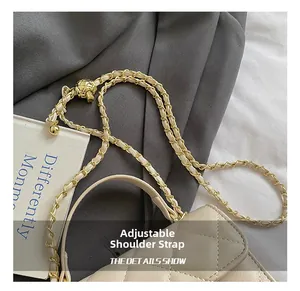 Close-up of beige quilted leather bag with adjustable golden ball chain strap detail