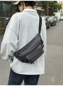 Detail view of washed denim crossbody bag with adjustable strap and multiple zip pockets