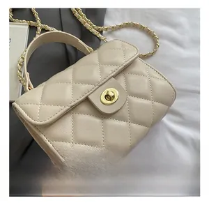 Close-up of golden metal twist lock and quilted lychee leather texture on the bag