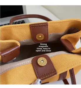 Détail du fermoir magnétique sécurisé sur un sac cabas en toile avec garniture en cuir