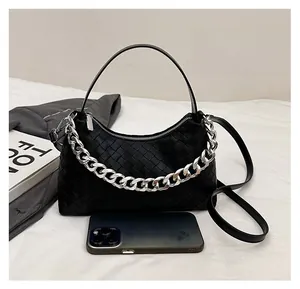 Detail of black woven shoulder bag featuring thick silver chain and intrecciato texture