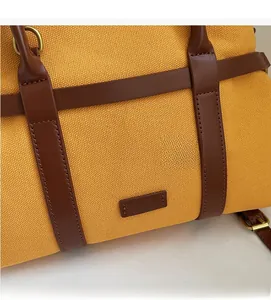 Détails du sac seau en toile jaune avec finitions en cuir brun et anneaux dorés