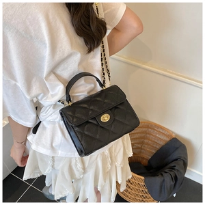 Detail of classic black quilted leather texture and gold chain strap on a crossbody bag