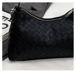Close-up of black woven leather texture and silver zipper on the stylish dumpling bag