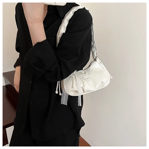 Détail du sac nuage plissé blanc avec nœud en dentelle, perles et finition en cuir