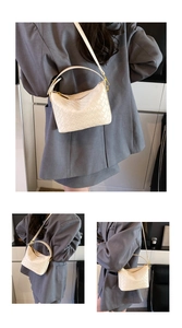 Close-up of white woven crossbody bag texture with adjustable strap and carry handle