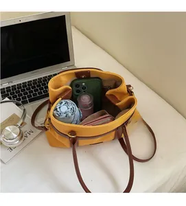 Vue de dessus de l'intérieur du grand cabas en toile avec anses cuir et objets du quotidien