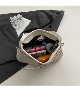 Top-down view of a cream white pleated shoulder bag showing a spacious interior storage