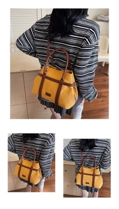 Détail du sac seau en toile jaune avec finitions en cuir et poignées supérieures robustes