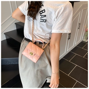 Detailed side view of pink quilted mini bag with gold chain strap on model