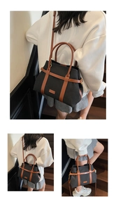 Vue détaillée du grand sac seau en toile avec poignées en cuir marron et bandoulière