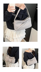 Détail de la texture plissée verticale fine et de la ceinture décorative du sac gris clair