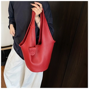Detail of red lychee grain leather bucket bag featuring a classic tied drawstring closure