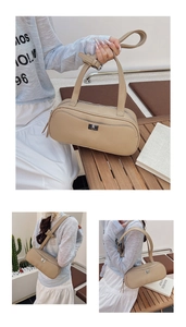 Detail einer Handtasche aus Leder mit Litschimuster, Drehverschluss und Schultergurt
