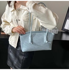 Grand sac cabas bleu clair en similicuir avec détail noué porté par un mannequin