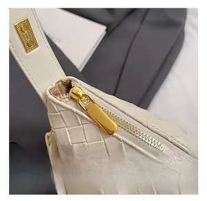 Close-up of woven texture and premium gold zipper on a chic off-white handbag