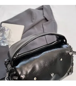 Detailed top view of black faux leather tote with silver heart studs and zipper