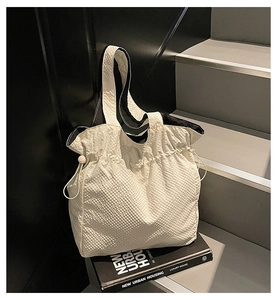 Dettaglio della borsa tote in nylon crema con texture a bolle e chiusura a coulisse