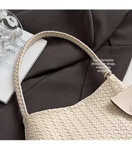 Detail of woven beige leather shoulder strap with intricate handmade texture and patterns