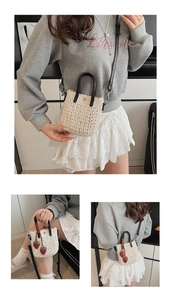 Vue détaillée du mini sac tissé crème avec anses en cuir noir et breloques fraises