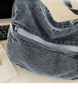 Detail view showing textured denim fabric and zipper closure of the large blue tote bag