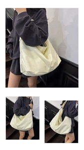 Primer plano de un gran bolso tote de lona beige con correa ancha y textura de tela suave