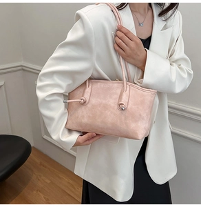 Détail de la bandoulière nouée sur un cabas en cuir rose au style rétro chic