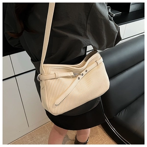 Detail of creamy white pleated texture leather handbag with adjustable silver buckle strap