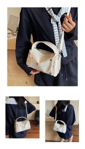 Detail of white PU leather crossbody bag with heart rivets and pleated ruffle trim