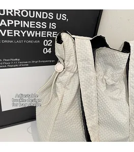 Dettaglio della coulisse regolabile sulla borsa tote in nylon beige per variare la forma