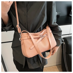 Détail du sac à bandoulière plissé rose montrant la texture du cuir et les boucles métalliques