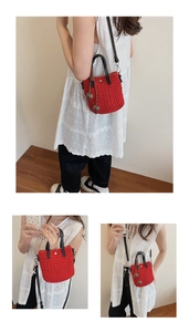 Vue détaillée du mini sac cabas en crochet rouge avec charms fraises et anses en cuir
