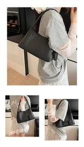 Close-up of black hand-woven hobo bag with unique pebble charm and shoulder strap detail
