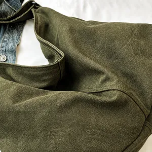 Primer plano del bolso tote de lona verde militar con textura de sarga gruesa y tela duradera