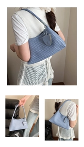 Close-up of fog blue woven hobo bag showing intricate checkerboard weave and round pendant