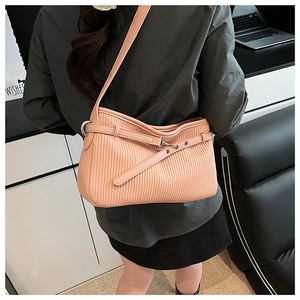 Detail of pink-orange shoulder bucket bag featuring unique vertical pleated texture and buckle