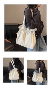 Dettaglio della borsa tote off-white con coulisse in tessuto strutturato e tracolla larga