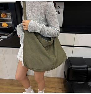 Bolso hobo grande de lona verde oliva con correa ancha mostrado en una modelo