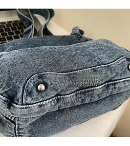 Detail of blue washed denim fabric with silver rivet decorations and twill texture
