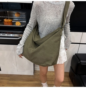 Bolso hobo de lona verde oliva llevado por una modelo en un ambiente casual