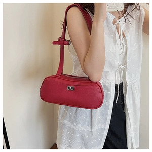 Model mit weinroter Zylindertasche aus Litschi-Leder mit silbernem Drehverschluss und Gurt
