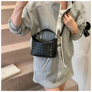 Detailed view of black woven faux leather hobo handbag with gold chain strap and zipper