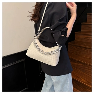 Detail of cream woven leather hobo bag with silver chain and moon-shaped design
