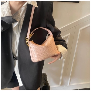Close-up of pink woven leather texture and golden metal hardware on a fashion handbag
