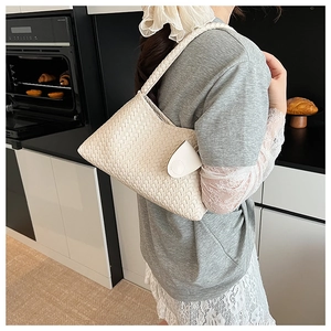 Detail of white hand-woven leather underarm bag with minimalist semi-circular buckle flap