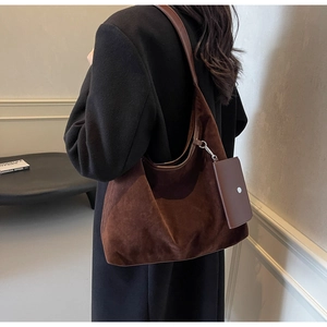 Detail of dark brown suede tote bag featuring a detachable small purse and silver clip