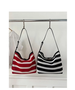 Détail de sacs fourre-tout à rayures rouge et noir avec maille et lanières en cuir