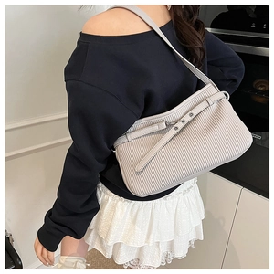 Détail du sac à bandoulière plissé gris clair avec garniture en cuir et rivets