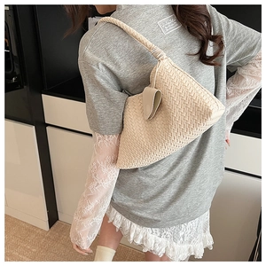 Detailed close-up of ivory woven hobo bag showing intricate leather texture and knot design